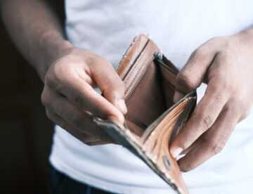 osoba pokazująca swój pusty portfel
